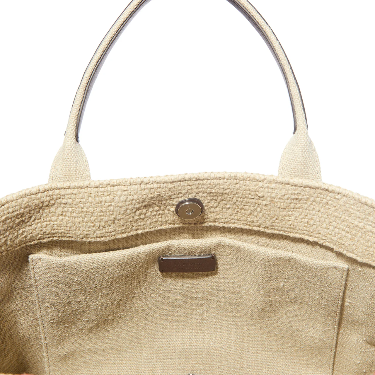 フラットポケットに型押しロゴのひかえめなレザータグが付く