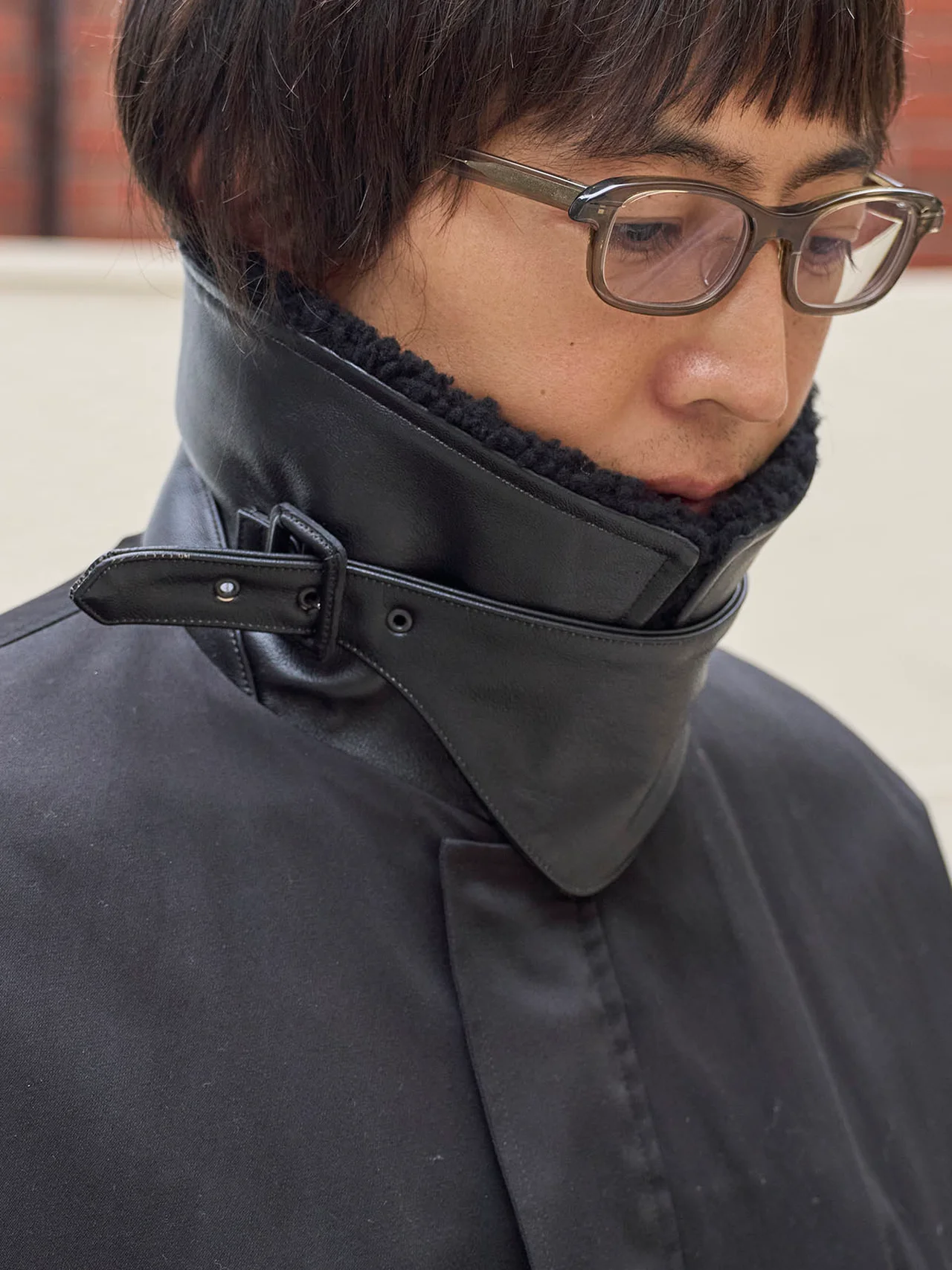 カウレザーを裏に配したシープムートンの襟とレザーのチンストラップ付き