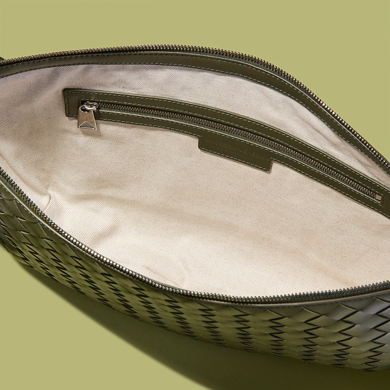 内側はキャンバスライニングで、ファスナーポケットと２つのオープンポケットを装備