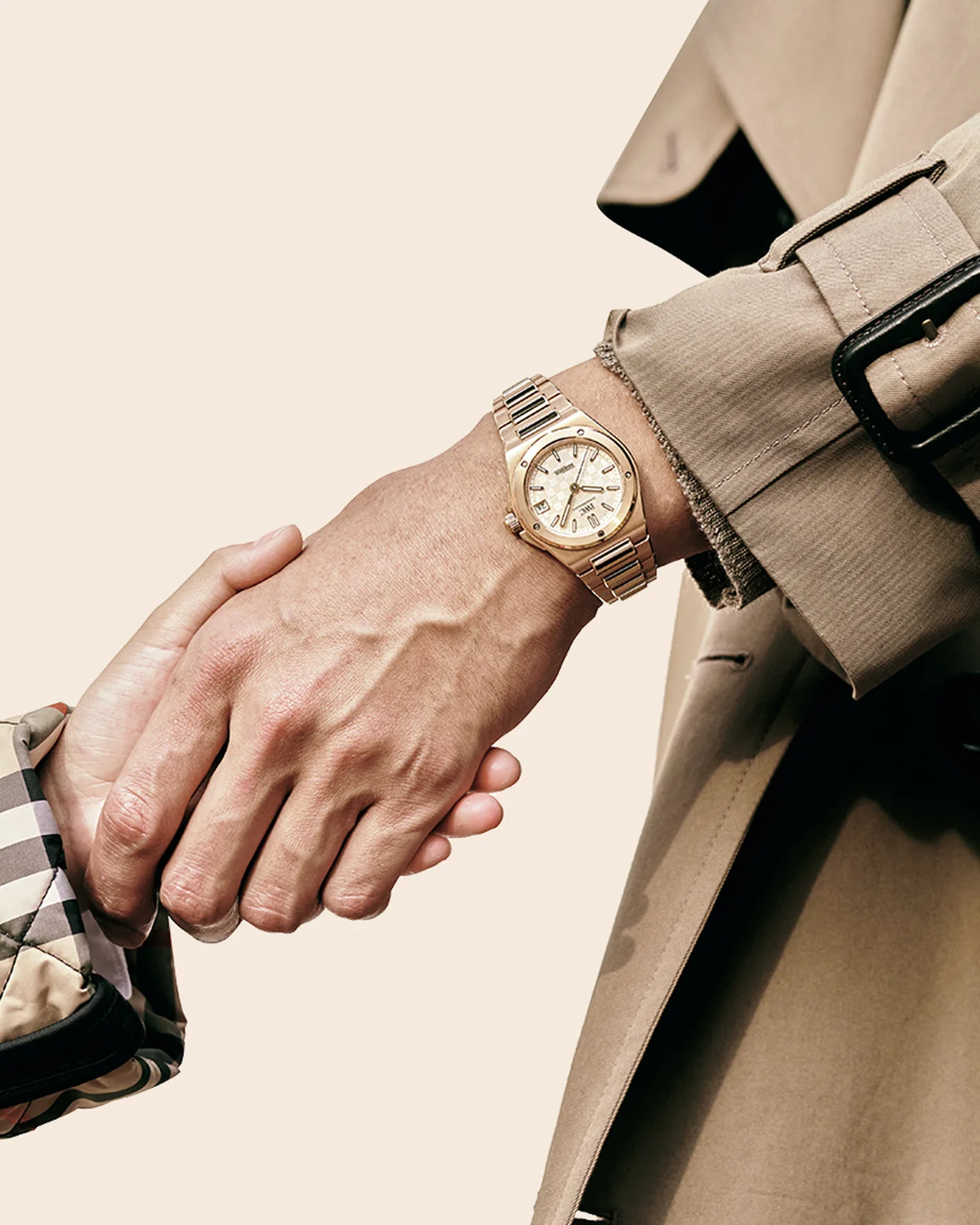 金無垢の時計とベージュのトレンチコート